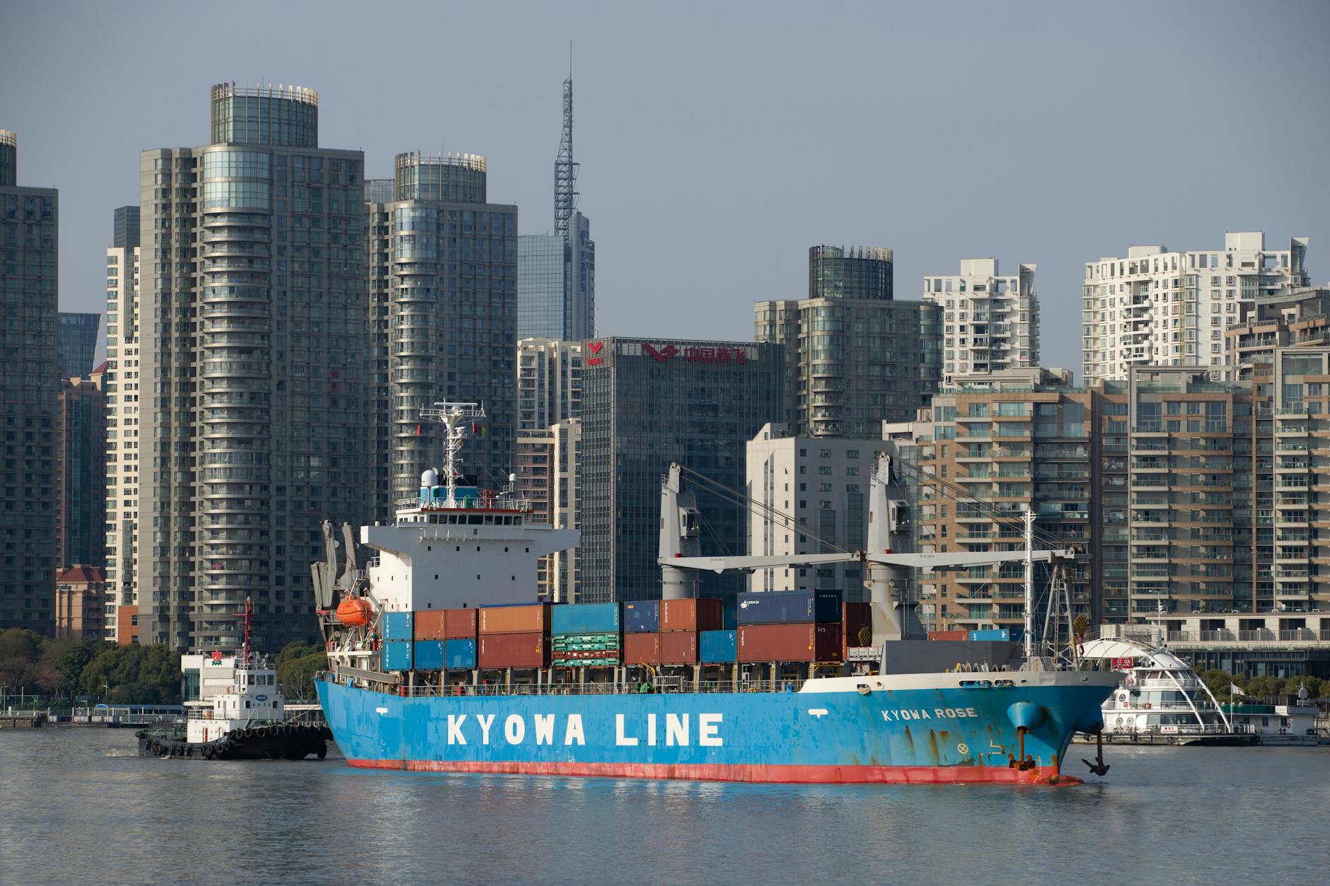 shaghai port A blue container ship in front of a modern urban skyline, reflecting global trade.