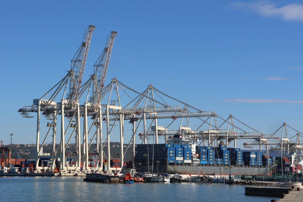 View of large port cranes and shipping containers at the harbor in Koper, Slovenia.